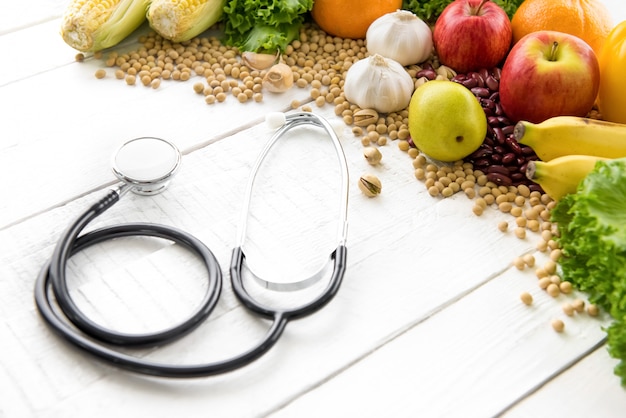 Nourriture saine, mélange de fruits et de noix, avec stéthoscope sur table en bois