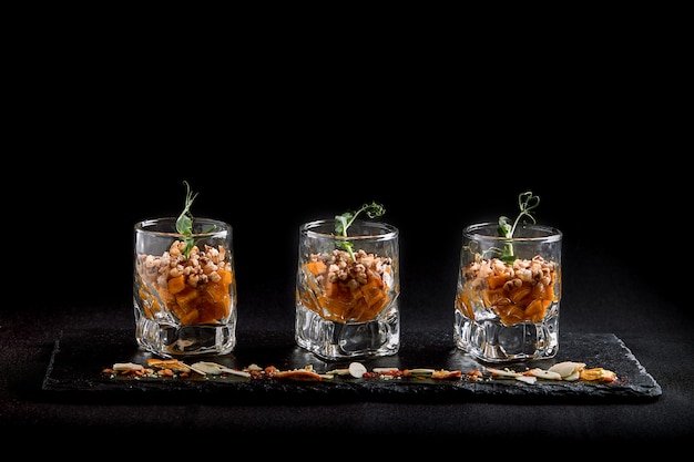 Nourriture saine, muesli végétarien végétalien à base de sarrasin vert et de graines de citrouille dans un verre takan. Concept de cuisine fusion, discret, espace copie.