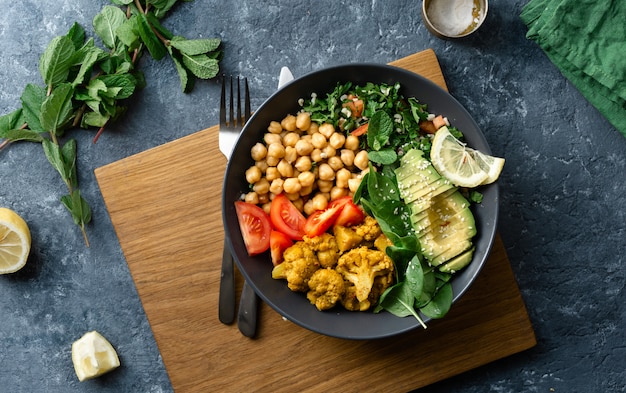 Nourriture saine végétarienne avec pois chiches, tomates, avocat et épinards