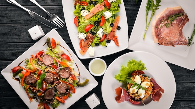 Nourriture Salades de légumes saumon veau steak viande Sur un fond en bois Vue de dessus Espace libre pour le texte