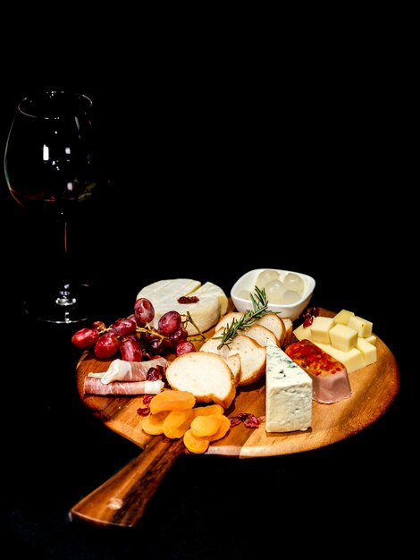 Nourriture Still Life fromage raisins craqueurs brie fromage bleu fromage bacon sur un fond sombre tapas