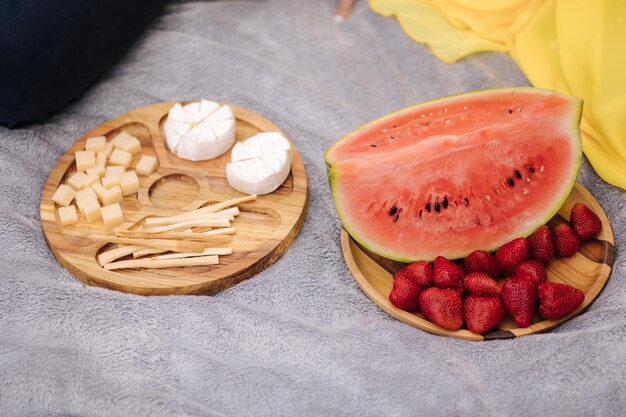 Nourriture sur table en bois à l'extérieur du concept de pique-nique tranches de citrouille et fraise différents types de fromage