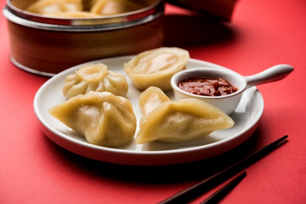 Nourriture traditionnelle de momos de boulette du Népal servie avec le chutney de tomate au-dessus du fond de mauvaise humeur. Mise au point sélective