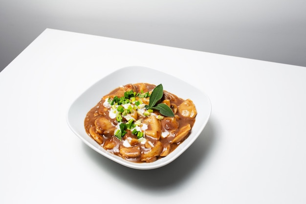 Nourriture végétalienne Boulettes maison avec pommes de terre et champignons en sauce sur blanc