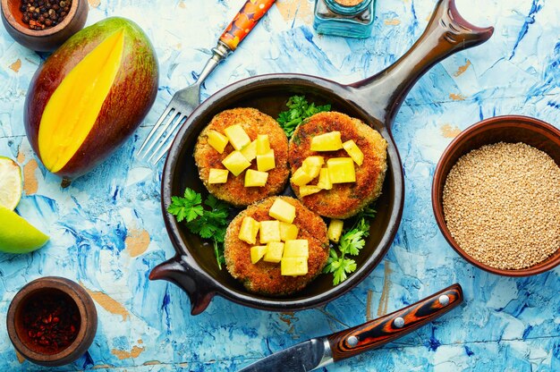 Nourriture végétalienne, escalope de quinoa garnie de mangue. Burger végétarien au four