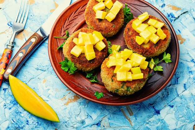 Nourriture végétalienne, escalope de quinoa garnie de mangue. Burger végétarien au four