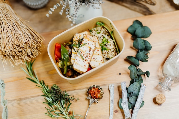 nourriture végétalienne riche en vitamines avec couscous au tofu paprika et champignons dans une boîte écologique livrée