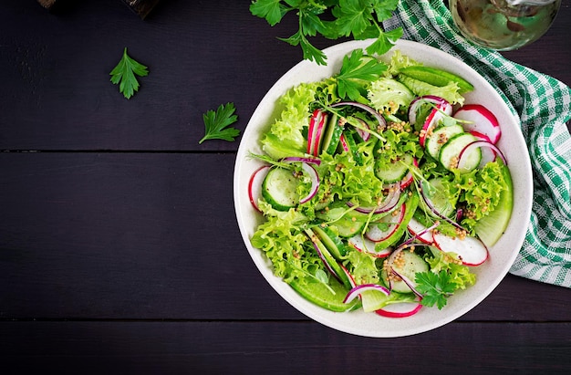 Nourriture végétalienne saine Salade de légumes végétariens de radis, de concombres, de laitue et d'oignons rouges