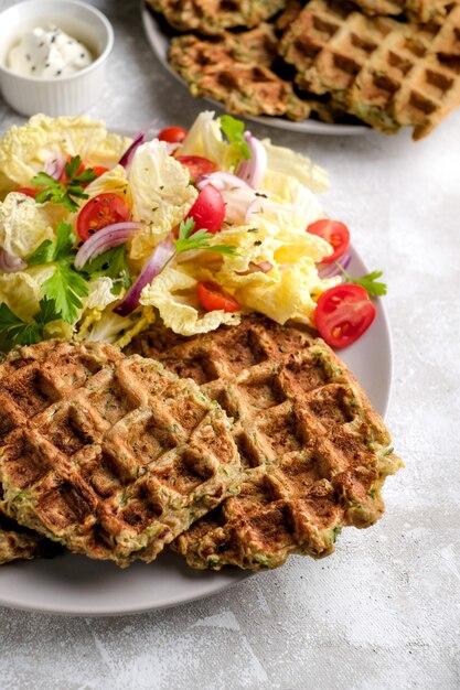 Nourriture végétarienne de gaufres aux légumes avec salade verte, tomates sur une assiette