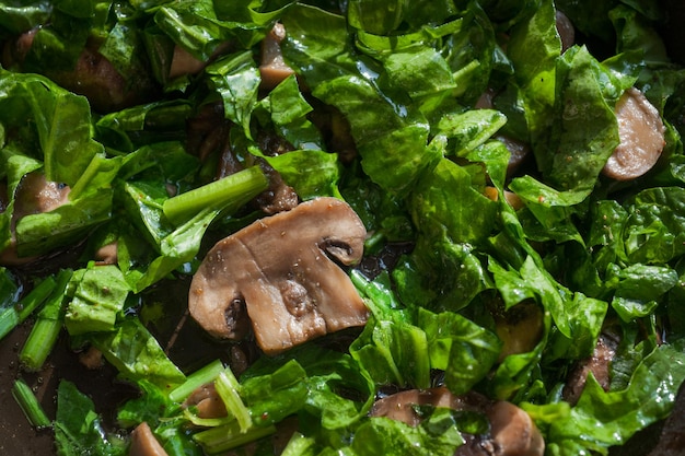 Photo nourriture végétarienne saine avec des épinards et des champignons ragoûtés gros plan d'épinards et de champignons