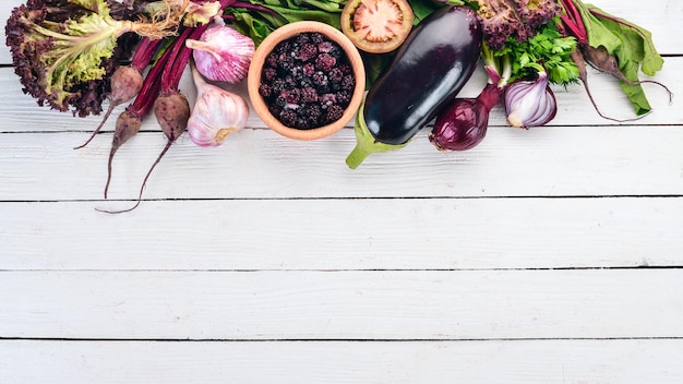 Nourriture violette Légumes frais et baies Sur un fond en bois blanc Vue de dessus Espace de copie