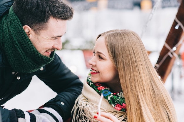 Nous aimons l'hiver. Portrait de taille d'un jeune couple d'amoureux heureux se regardant et souriant. Ils portent des manteaux chauds et des écharpes