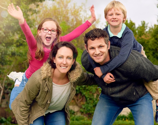 Nous aimons les week-ends en famille Portrait d'une jeune famille debout ensemble à l'extérieur