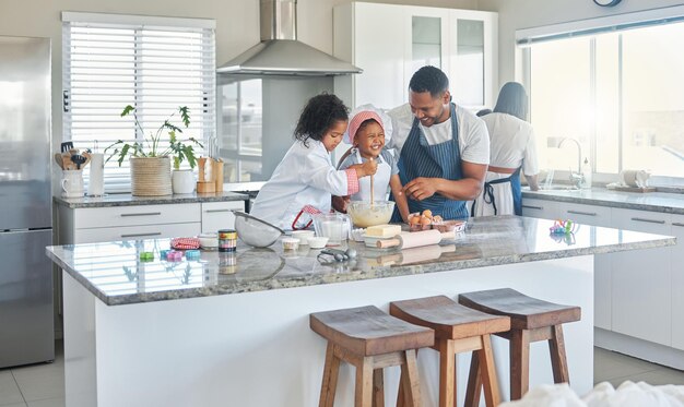 Nous avons toujours voulu aider en cuisine. Plan d'un père cuisinant à la maison avec ses deux filles.