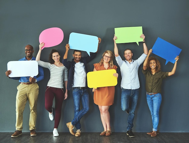 Nous avons tous une opinion qui compte Prise de vue en studio d'un groupe diversifié de personnes tenant des bulles sur un fond gris