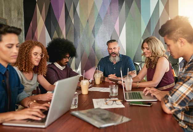 Nous créons, nous travaillons dur et nous collaborons Photo recadrée de collègues créatifs ayant une réunion dans un bureau moderne