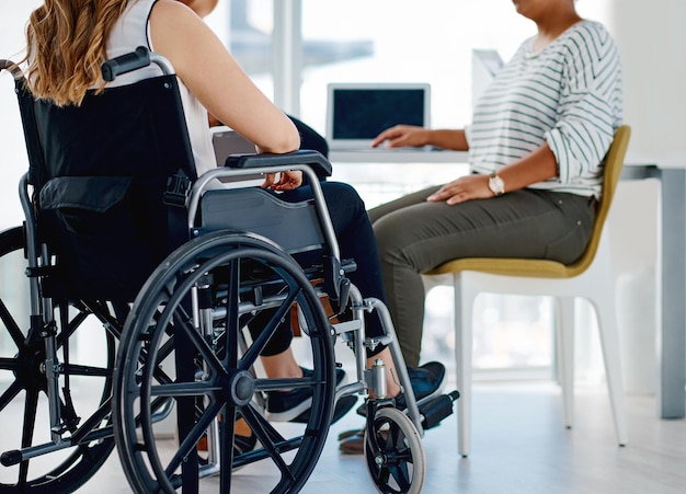 Nous mettons tous la même quantité de travail Photo d'une femme d'affaires handicapée assise avec des collègues au bureau