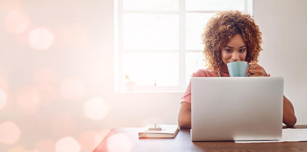 Nous ne manquons jamais d'être inspirés et motivés par la technologie Photo recadrée d'une jeune designer prenant un café tout en travaillant sur son ordinateur portable sur un arrière-plan amélioré numériquement