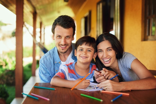 Nous prenons le temps de partager des moments spéciaux ensemble Portrait d'un couple et de leur fils en train de colorier ensemble à l'extérieur