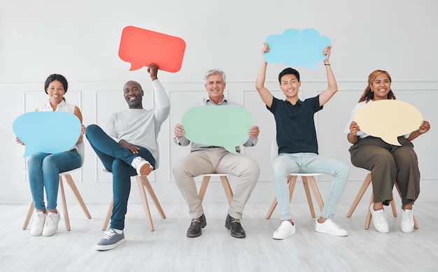 Photo nous voulons que nos opinions soient également entendues portrait d'un groupe diversifié de personnes tenant des bulles colorées tout en étant assis en ligne sur un fond blanc