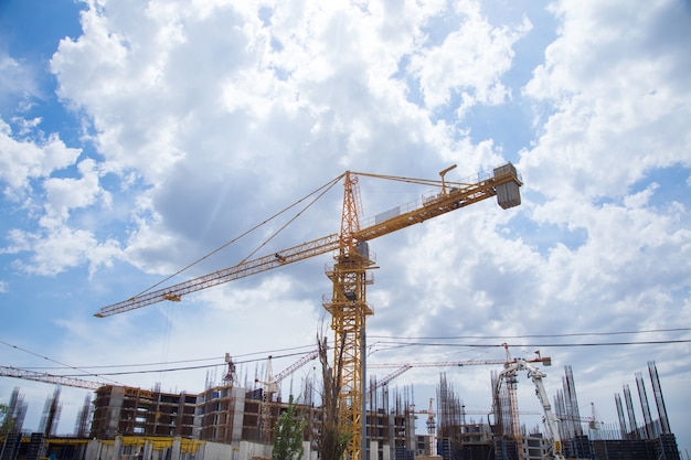 Nouveau bâtiment et grues sous les nuages