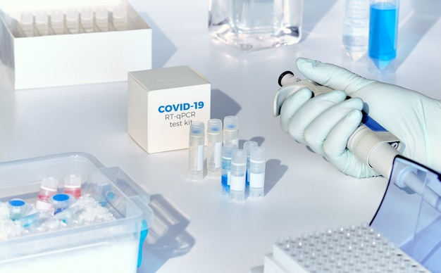 Nouveau kit de test rapide pour coronavirus COVID-19. Kit de diagnostic nCoV pcr 2019. La main dans le gant avec une pipette.