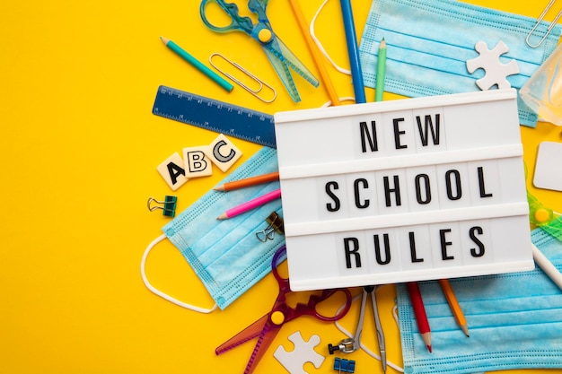 Photo nouveau message de règles scolaires avec équipement scolaire et masques covid