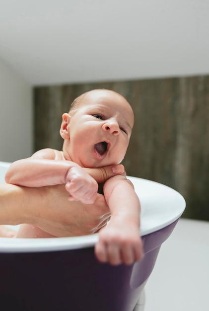 Nouveau-né bâillant dans la baignoire