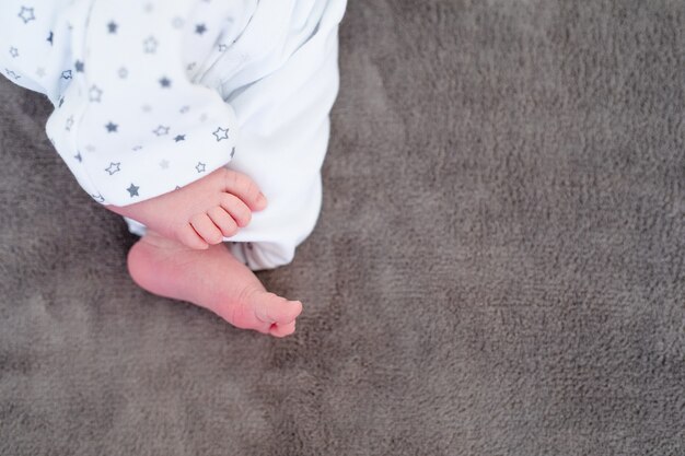 Nouveau-né sur une couverture blanche - petit bébé pieds gros plan.