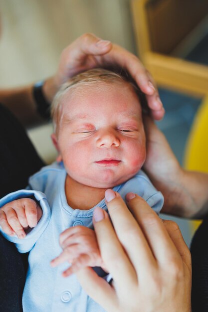 Un nouveau-né dans les bras de sa mère et de son père allongé sur leurs bras vue de haut en gros plan Des jeunes parents tiennent leur petit bébé Style de vie sain Paternité