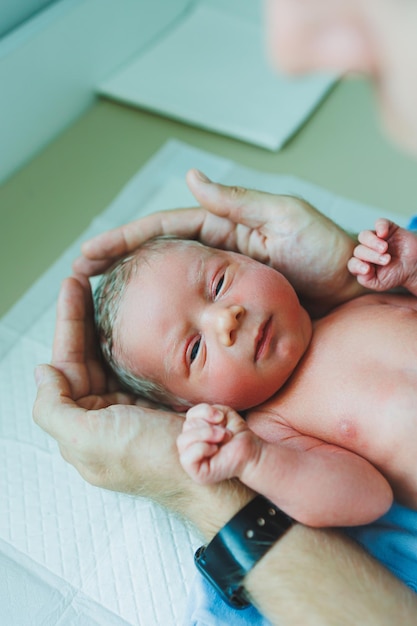 Un nouveau-né dans les bras de son père allongé sur ses bras vue de haut en gros plan Un homme tient un petit enfant Mode de vie sain Paternité