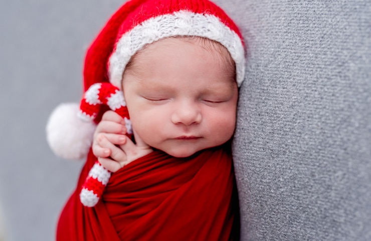 Photo nouveau-né dormant avec des bonbons de noël tricotés