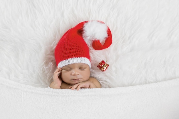 Nouveau-né dormeur dans un bonnet de Noël Père Noël