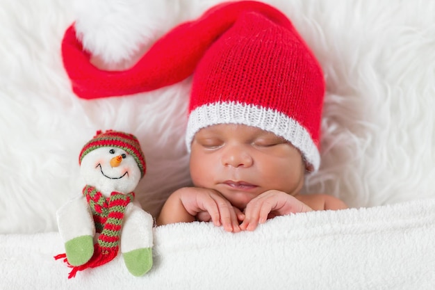Nouveau-né dormeur dans un bonnet de Noël Père Noël