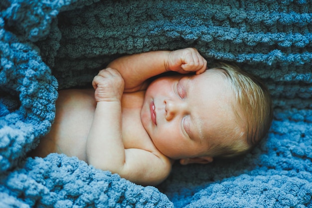 Un nouveau-né dort sur une couverture tricotée Une couverture en tissu naturel pour un nouveau-né