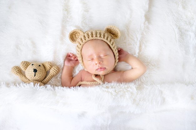 Un nouveau-né dort avec un ours en peluche