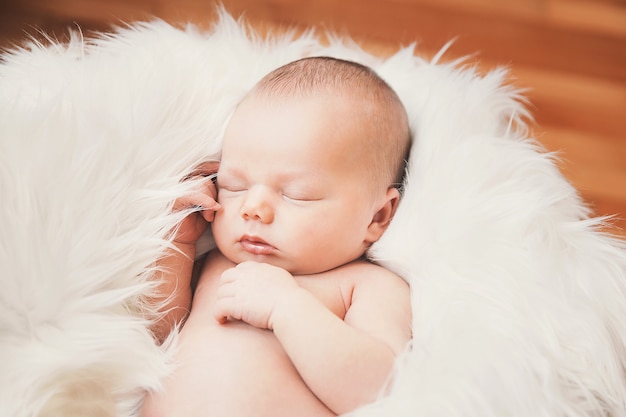 Nouveau-né endormi dans une enveloppe sur une couverture blanche. Beau portrait de petite fille de 7 jours, une semaine.