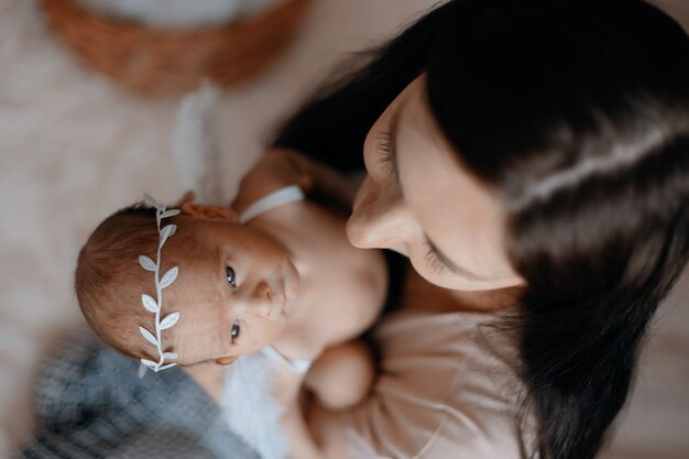 Nouveau-né mignon de plan rapproché dans les bras de sa mère