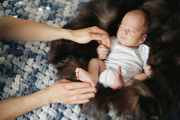 Le nouveau-né s'accroche au doigt de sa mère pendant son sommeil