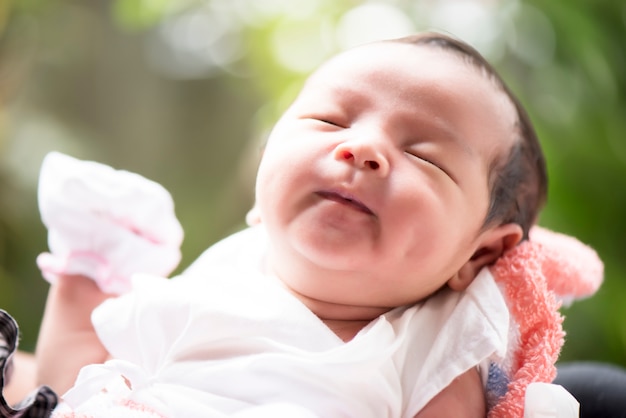 Nouveau-né souriant dans les mains de la mère, mise au point sélective dans ses yeux, concept de famille