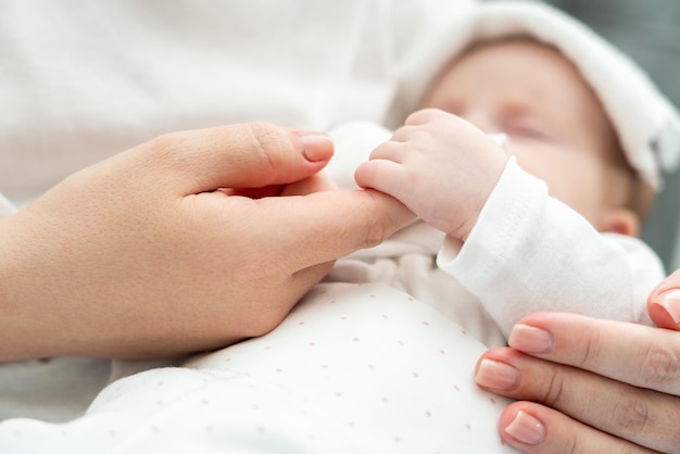 Photo le nouveau-né trouve du réconfort en tenant le doigt de sa mère pendant sa maladie.