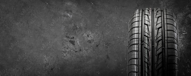 Photo nouveau pneu d'été directionnel sur une vue de face de fond texturé