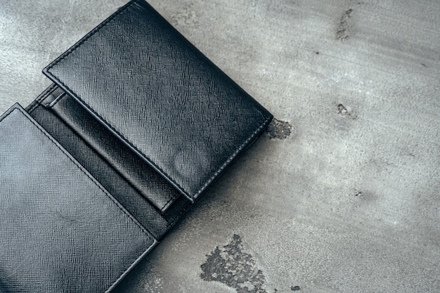 Nouveau portefeuille en cuir noir sur fond de béton gris