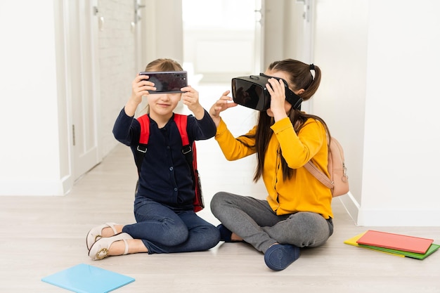 Nouveau programme. Écolière progressive intelligente visitant des cours d'informatique et touchant l'écran à deux mains tout en portant des lunettes de réalité virtuelle.