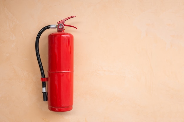 Nouveau réservoir d&#39;extincteur rouge sur mur orange