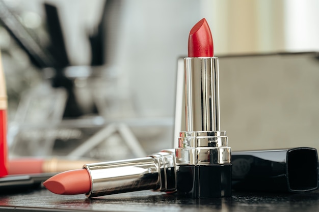 Nouveau rouge à lèvres rouge sur la table de toilette se bouchent