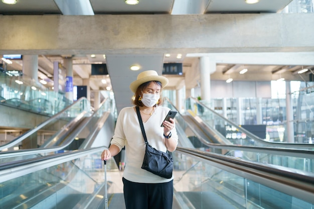 Un nouveau touriste normal portant un masque facial voyage sur l'aéroport