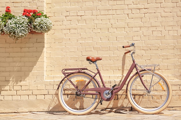 Nouveau vélo élégant près du mur de briques à l'extérieur