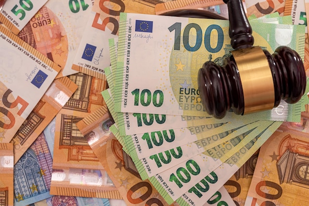 Les nouveaux billets en euros purs vert et orange sont ornés d'un puissant marteau de juge en bois. Notion d'argent. Notion d'entreprise. Notion de richesse