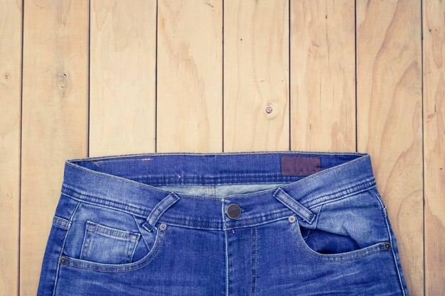 Nouveaux jeans bleu sur la vue de dessus de fond en bois